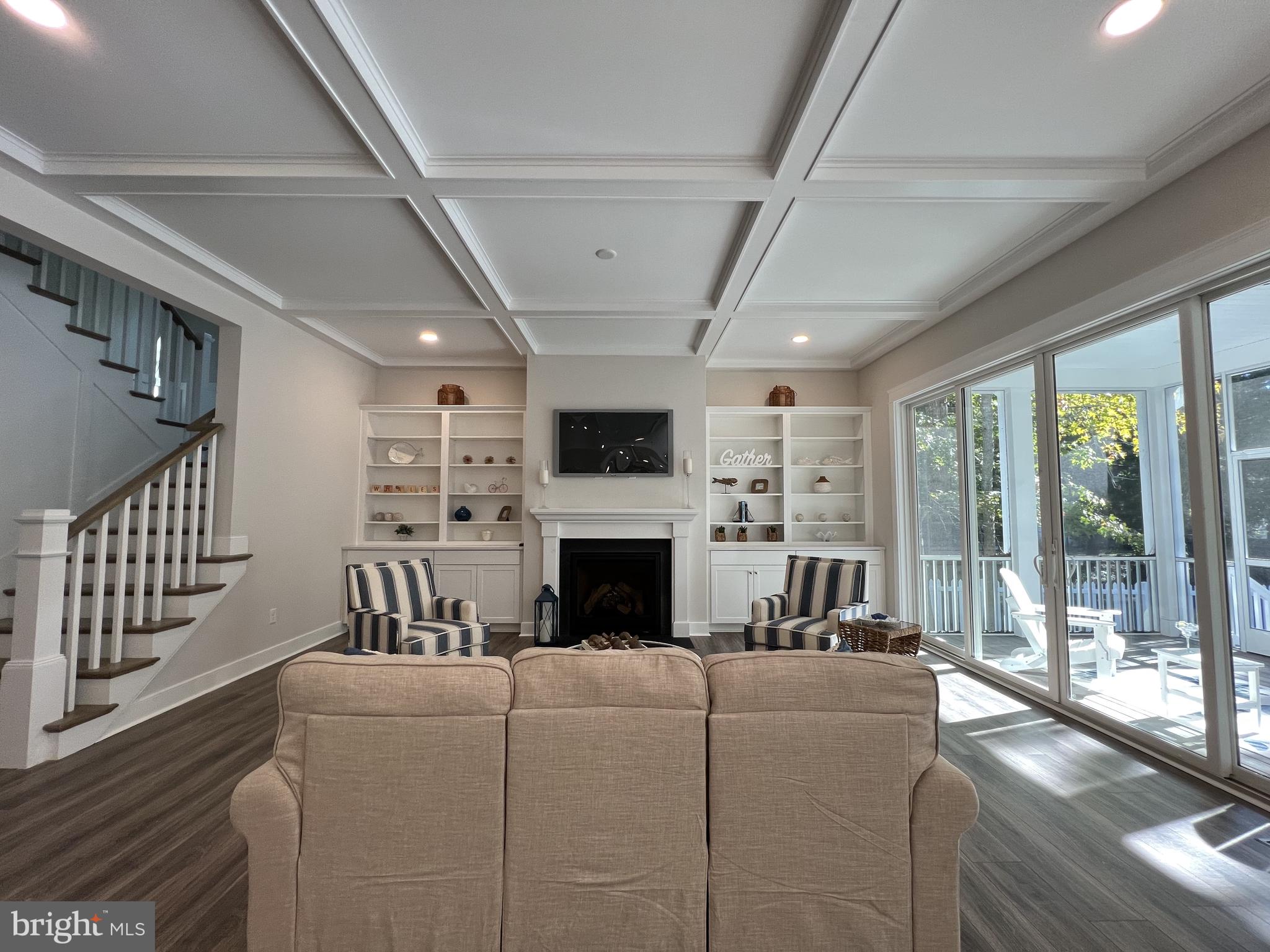 30491 Blue Beech Lane Frankford, DE 19945 - Photo 11 of 17 a living room with furniture a fireplace and a floor to ceiling window