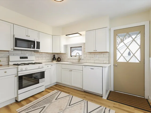 a kitchen with cabinets stainless steel appliances and a window