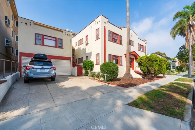 a view of a white house with a yard and plants