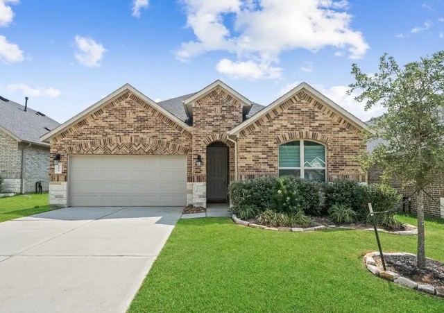 a front view of a house with a yard and garage