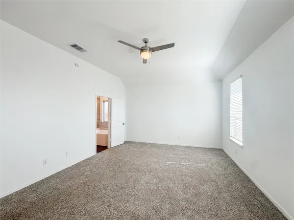 an empty room with a window and a ceiling fan