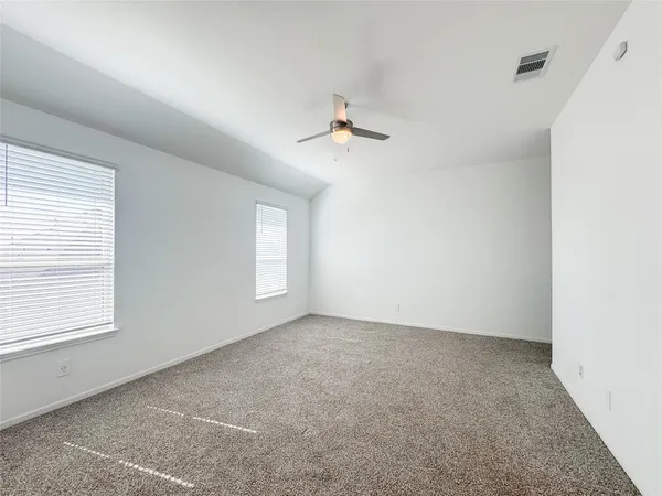 an empty room with a window and a ceiling fan