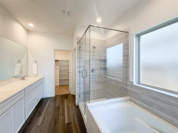 a bathroom with a double vanity sink toilet mirror and bathtub