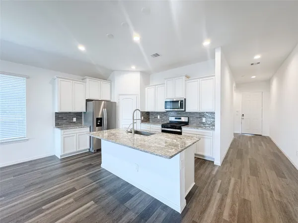 a kitchen with stainless steel appliances a refrigerator sink and cabinets