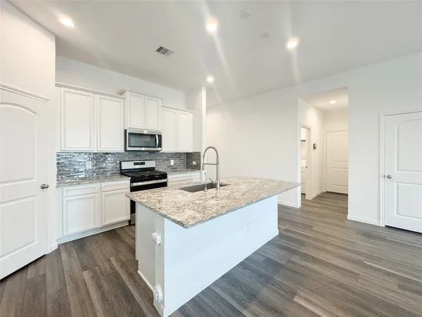 a kitchen with granite countertop white cabinets and white appliances