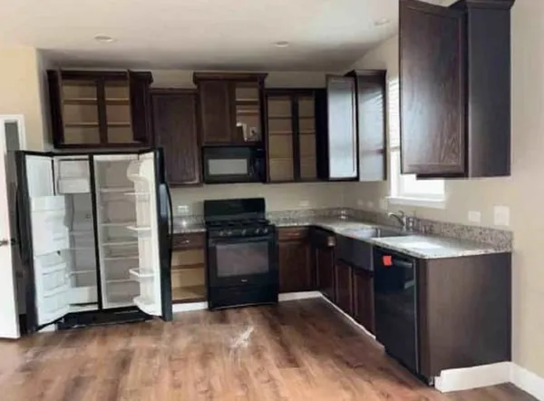 a kitchen with stainless steel appliances granite countertop a refrigerator and a stove top oven