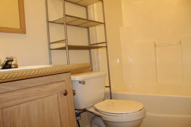 a bathroom with a granite countertop sink toilet and shower