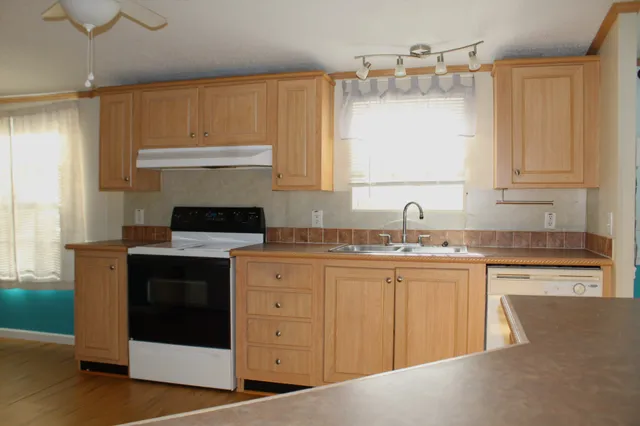 a kitchen with granite countertop a sink stainless steel appliances and cabinets