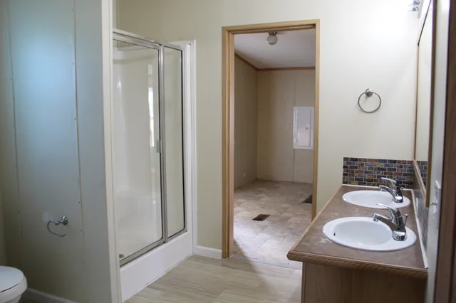 a bathroom with a granite countertop sink toilet and shower