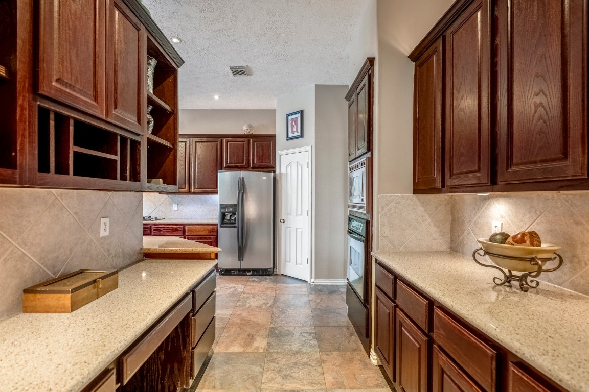 6811 PInehearth Court Spring, TX 77379 - Photo 15 of 50 From the doorway leading back to the foyer, this angle reveals the side of the kitchen that wasn’t visible before, with additional counter space and cabinetry surrounding the refrigerator and pantry. It’s a great setup for a coffee bar or butler’s pantry-style space, with so much storage and room to spread out.