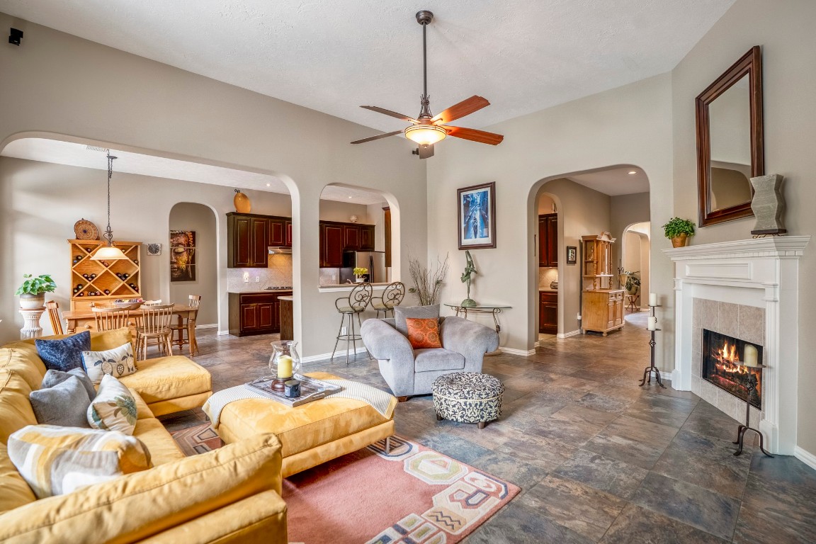 6811 PInehearth Court Spring, TX 77379 - Photo 23 of 50 Stepping back out from the primary suite, this view re-centers you in the living room and highlights how the home connects—through the archway ahead to the foyer, into the kitchen near the butler’s pantry area, and toward the formal dining just beyond the front entry. From here, we’ll head across the home to the secondary bedrooms near the breakfast area.
