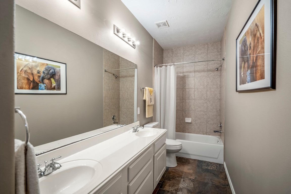 6811 PInehearth Court Spring, TX 77379 - Photo 26 of 50 Serving the secondary bedrooms, this full bath is designed with everyday ease in mind—featuring dual sinks, generous under-cabinet storage, and an extended vanity that keeps everything within reach. A tiled tub and shower surround adds a clean, cohesive finish while offering a comfortable space to start and end the day.