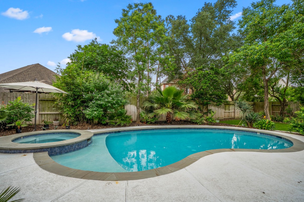 6811 PInehearth Court Spring, TX 77379 - Photo 31 of 50 The pool and spa take center stage here, surrounded by lush greenery that creates a private, resort-style setting. Recently refreshed with updated surface finishes and equipment, it’s a space designed for both relaxing afternoons and easy entertaining—whether you’re cooling off in the pool or unwinding in the spa at the end of the day.