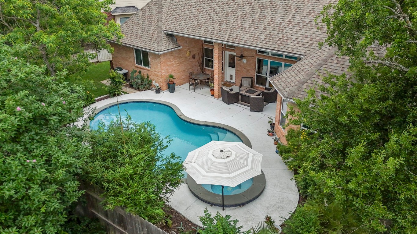 6811 PInehearth Court Spring, TX 77379 - Photo 36 of 50 From above, the backyard comes into full view—an inviting pool and spa framed by lush landscaping, with a covered patio that extends the living space outdoors on a generously sized lot designed for both relaxation and entertaining.