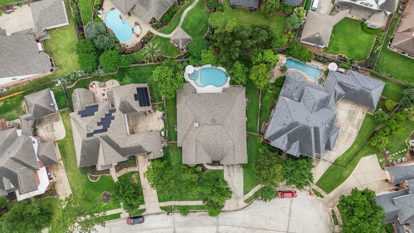 6811 PInehearth Court Spring, TX 77379 - Photo 37 of 50 From above, we get a clearer view of the spacious cul-de-sac lot. The backyard highlights the stretches of green lawn alongside the pool, and the 2020 roof adds an added layer of confidence for what’s already in place.