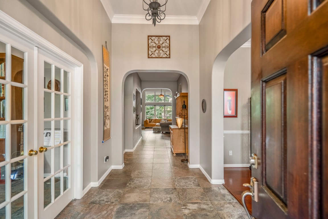 6811 PInehearth Court Spring, TX 77379 - Photo 4 of 50 From the moment you step in, the foyer sets the tone with elevated ceilings, tile flooring, and a series of arched openings that draw you into the main living spaces. To the left French doors lead into the private study while the archway to the right leads to the formal dining.