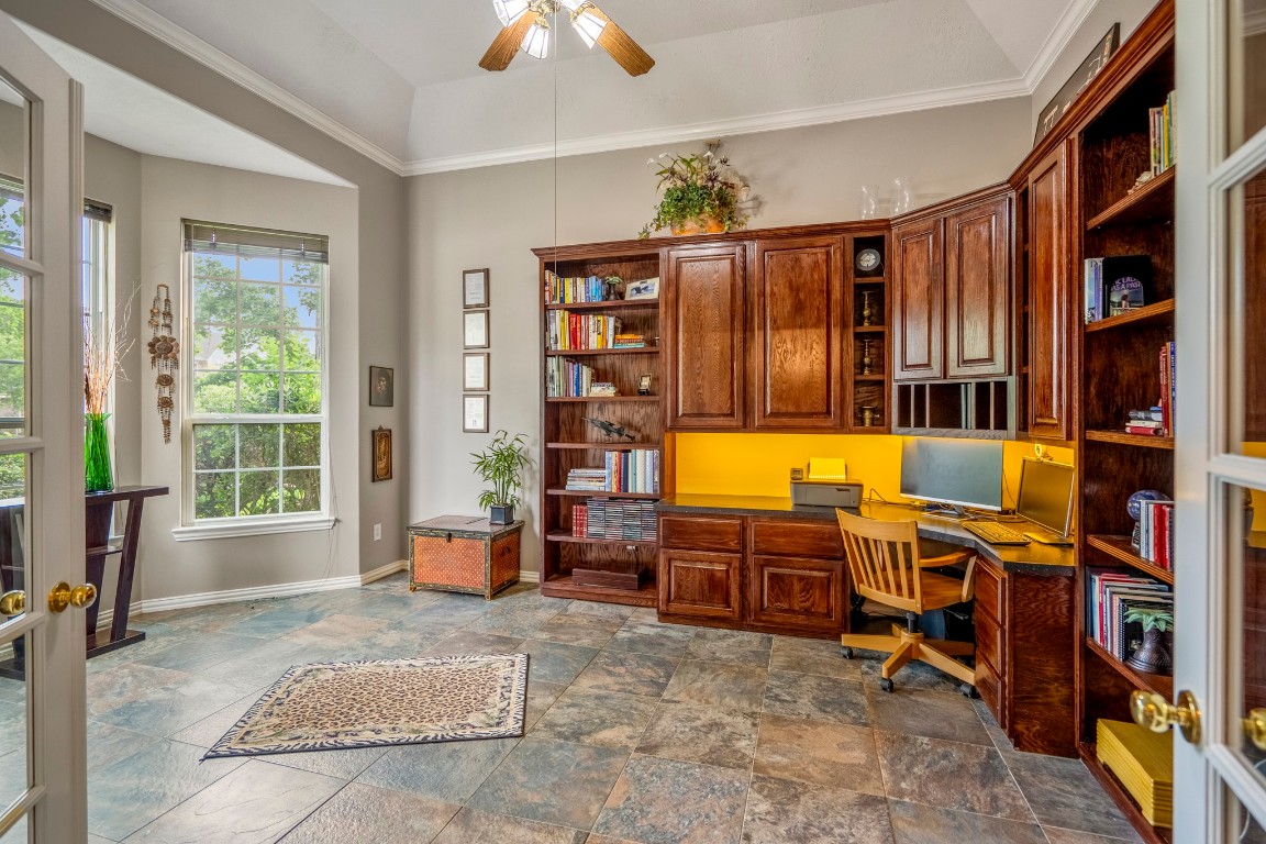 6811 PInehearth Court Spring, TX 77379 - Photo 5 of 50 Just off the foyer, the study sits behind French doors with a bay window that brings in natural light, along with tile flooring, a vaulted ceiling with crown moulding, and a ceiling fan—offering a space that feels both open and tucked away.