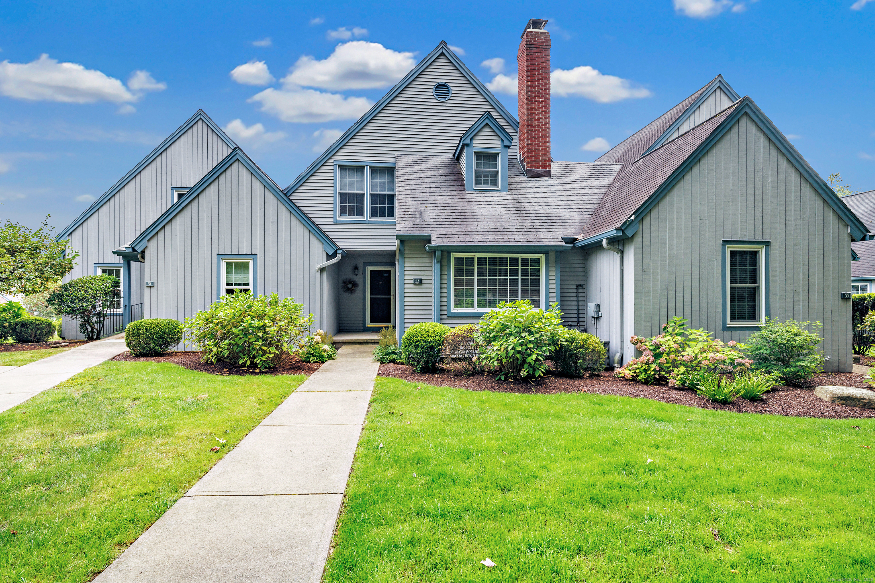 53 Blackmount Court, Unit 53 Fairfield, CT 06825 - Photo 1 of 1 a front view of a house with a yard and potted plants