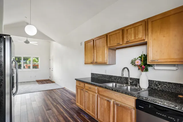 a kitchen with granite countertop stainless steel appliances and wooden cabinets