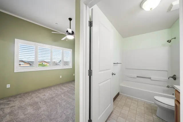 a bathroom with a granite countertop sink toilet a mirror and shower
