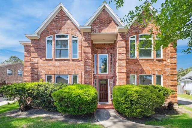 front view of a brick house with a small yard