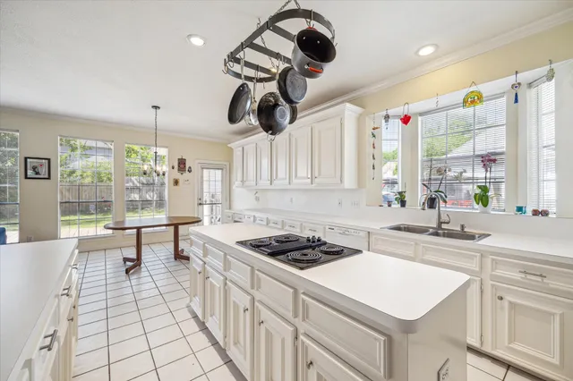 a kitchen with a sink a stove a dining table and chairs