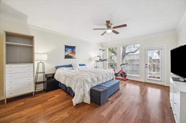a spacious bedroom with a bed and a flat tv screen on dresser