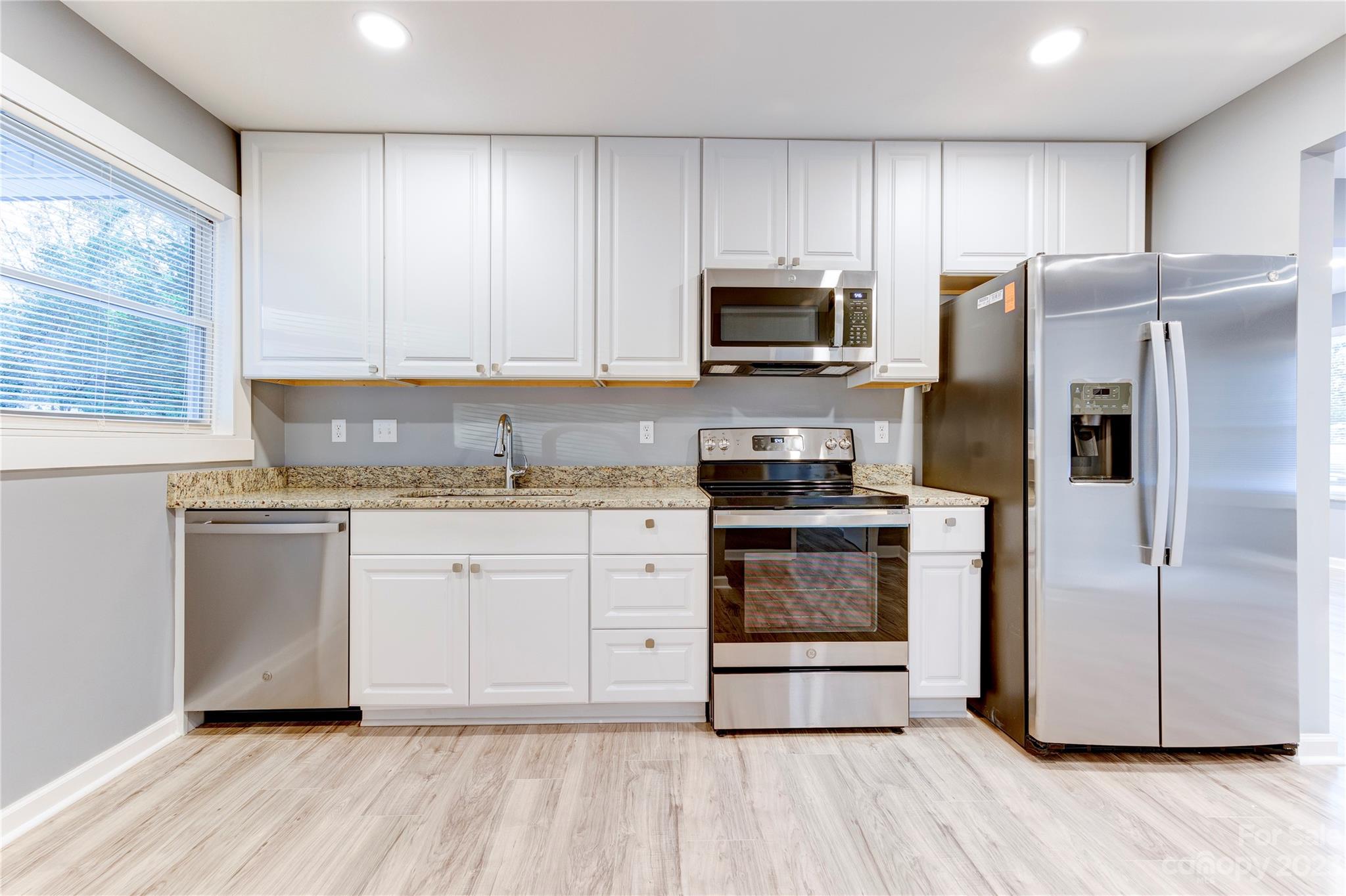 4641 Fallston Road Lawndale, NC 28090 - Photo 16 of 38 a kitchen with granite countertop white cabinets and stainless steel appliances