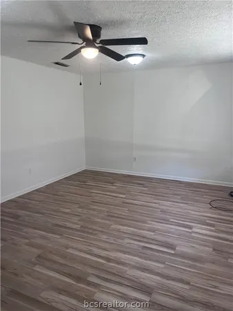 a view of an empty room with a ceiling fan