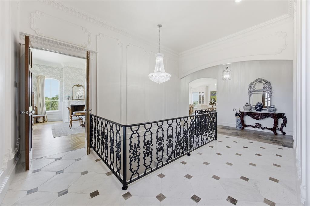 501 Upper Denton Road Weatherford, TX 76085 - Photo 17 of 40 Ornate wrought iron railing, decorative ceiling molding, crystal chandelier, tile flooring with inset accents, and arched entryways