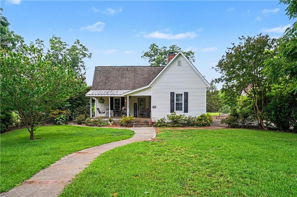 a front view of a house with a garden and trees