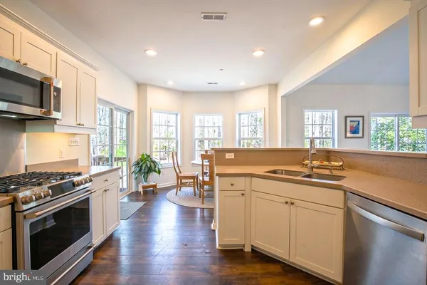 a kitchen with stainless steel appliances a stove sink and microwave