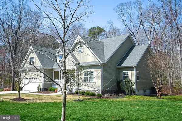 a view of house with a big yard plants and large trees