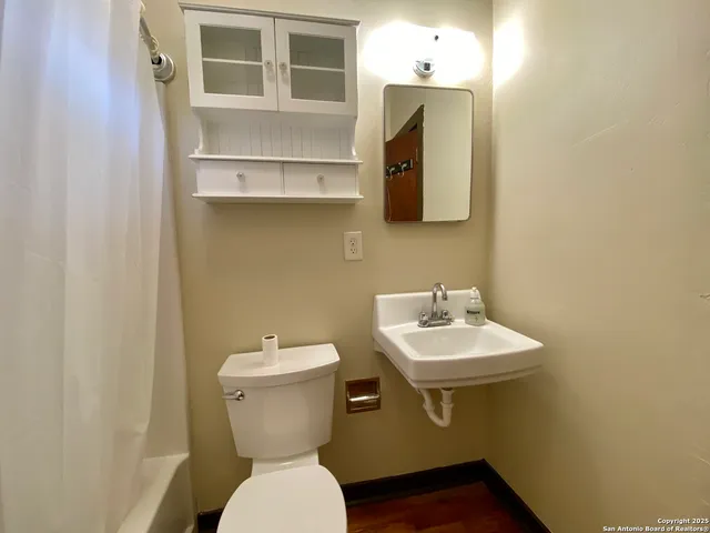 a bathroom with a toilet sink and mirror