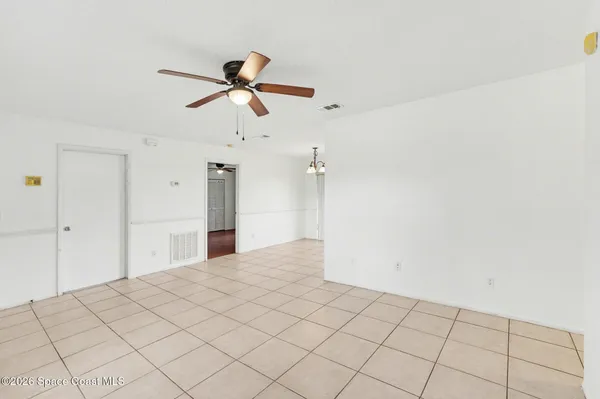 a view of a room with a ceiling fan and window