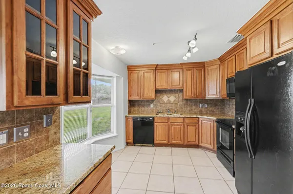 a view of kitchen with furniture and refrigerator