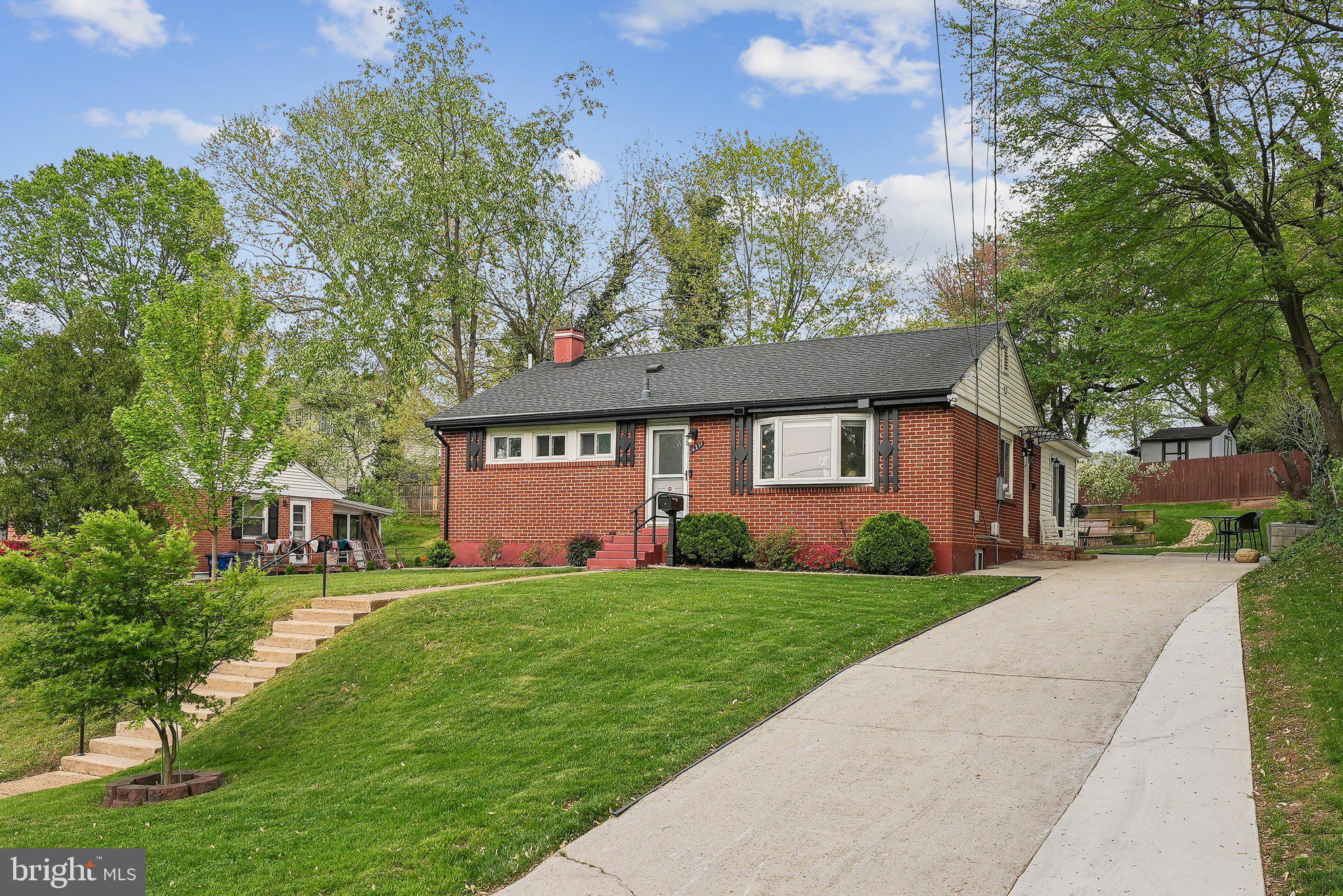 6211 Paulonia Road Alexandria, VA 22310 - Photo 1 of 37 a view of a brick house with a big yard and large trees
