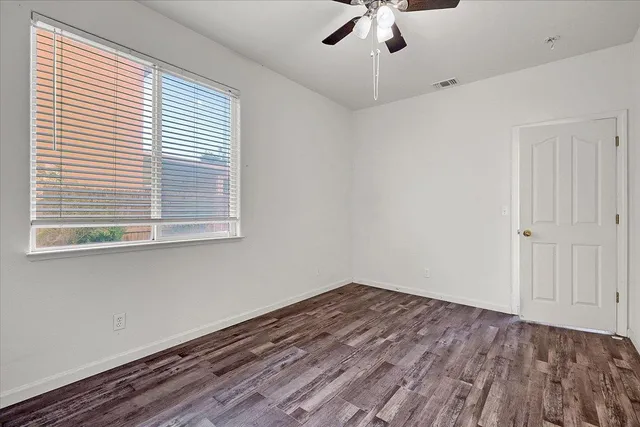 a view of an empty room with wooden floor