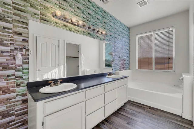 a bathroom with a double vanity sink and mirror