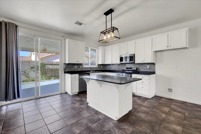 a kitchen with granite countertop white cabinets and white appliances