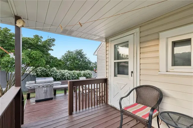 a balcony with wooden floor and outdoor seating