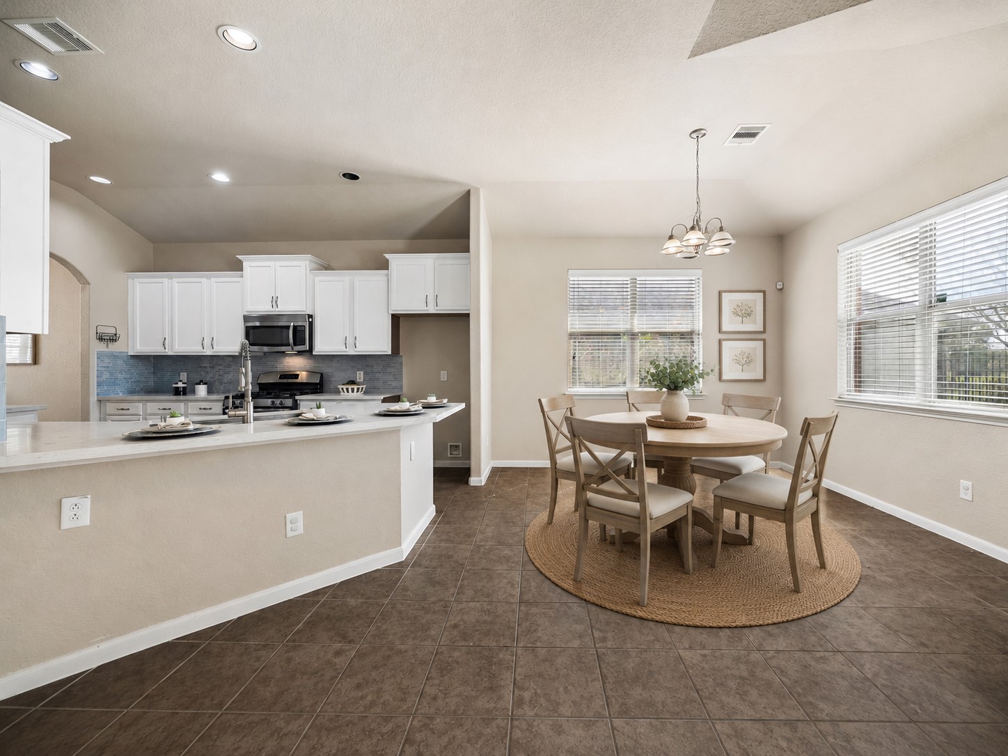 7806 Summer Night Lane Rosenberg, TX 77469 - Photo 10 of 23 The kitchen features white cabinetry and a blue tile backsplash, complemented by a breakfast bar that opens to a dining area with a chandelier and large window. **This room has been virtually staged.