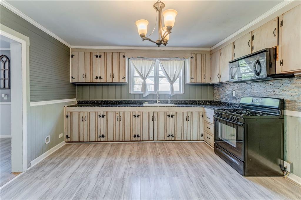 33 Elm Street Aragon, GA 30104 - Photo 11 of 34 a kitchen with granite countertop wooden floors a stove and a microwave