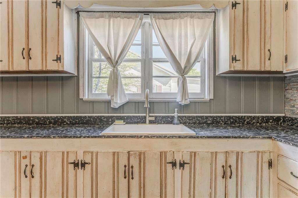 33 Elm Street Aragon, GA 30104 - Photo 16 of 34 a kitchen with granite countertop white cabinets and a window