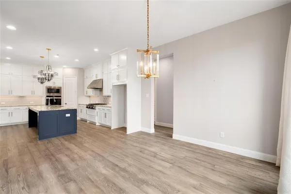 a living room with wooden floor and a ceiling fan