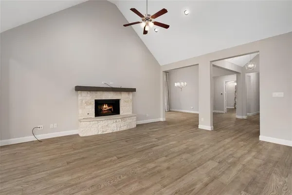 a view of kitchen and empty room with wooden floor