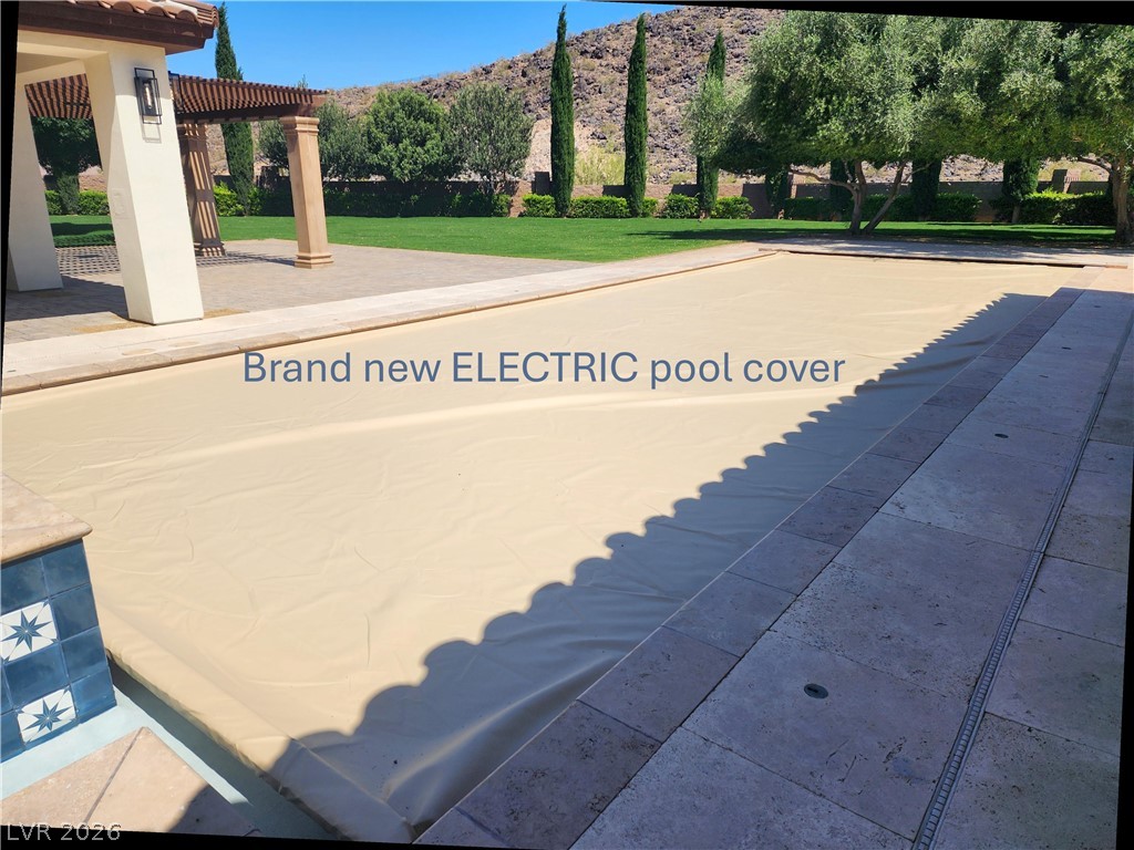 1140 Julie Road Henderson, NV 89002 - Photo 22 of 85 Relax poolside with this inviting outdoor oasis, featuring a covered pergola and lush landscaping.