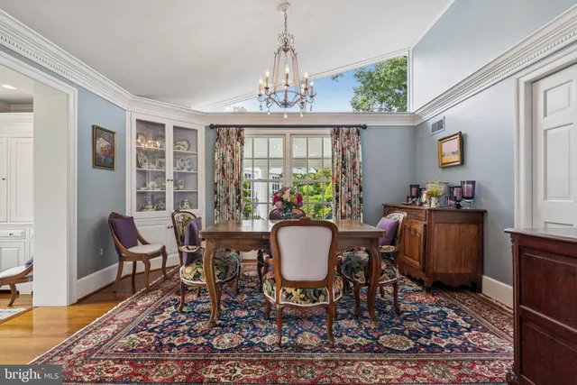 a dining room with furniture a rug and a chandelier