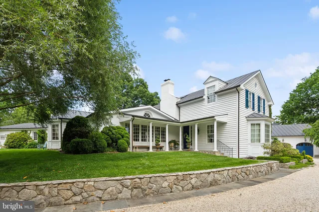 a front view of a house with a yard and potted plants