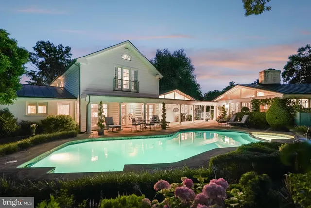 a view of a house with backyard sitting area and swimming pool